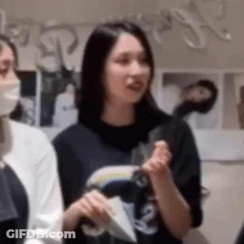 Woman In Mask And Black T-Shirt Next To Woman GIF
