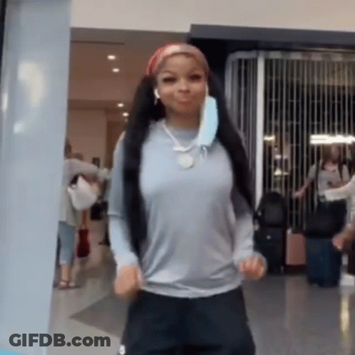 Woman In Mask And Headphones Dancing In Hallway GIF