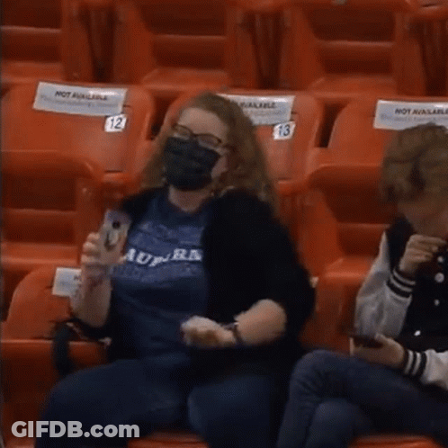 Woman In Mask Sitting In Empty Stadium With Not Available Sign GIF