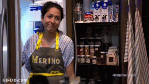 Woman In Merino Apron Standing In Front Of Refrigerator GIF