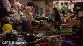Woman In Messy Room With Pile Of Clothes GIF