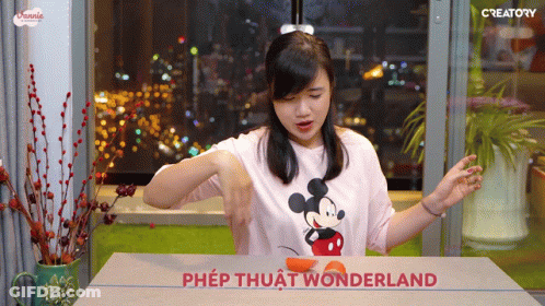Woman In Mickey Mouse Shirt Cutting Orange GIF
