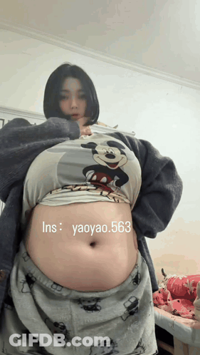 Woman In Mickey Mouse Shirt With Large Belly GIF