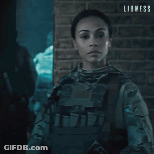 Woman In Military Uniform In Front Of Brick Wall Saying Lioness GIF
