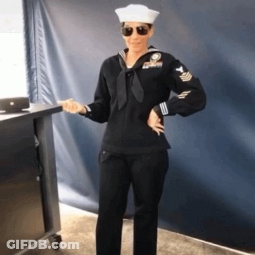 Woman In Navy Uniform In Front Of Blue Wall GIF