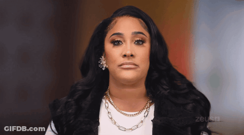 Woman In Necklace And Earrings Looking At Camera With Zeus TV Logo GIF