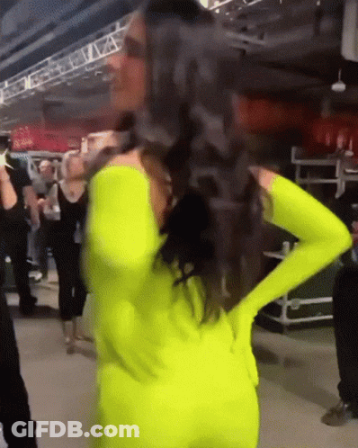 Woman In Neon Yellow Outfit Hands On Hips GIF