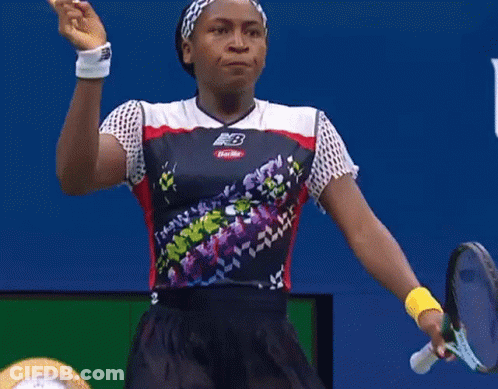 Woman In New Balance Shirt Pointing Up At Usopen.org Sign GIF