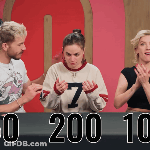 Woman In Number 7 Sweater In Front Of 0 200 10 Sign GIF