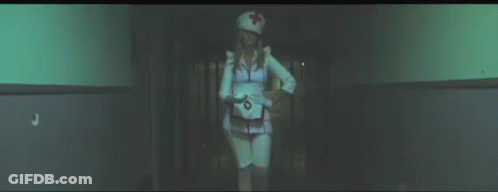 Woman In Nurse Costume Walking Down Hallway At Night GIF
