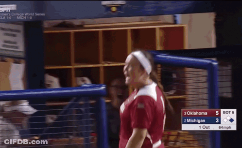 Woman In Oklahoma Softball Jersey In Front Of Scoreboard GIF