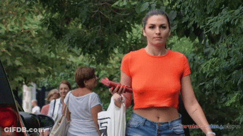 Woman In Orange Crop Top Walking Street GIF