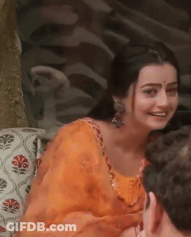 Woman In Orange Dress Sitting On Couch With Man Smiling GIF