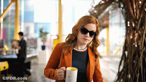 Woman In Orange Jacket Holding I Love You Mug GIF