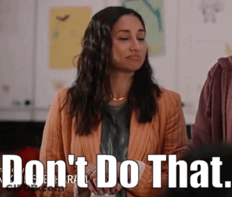 Woman In Orange Jacket Standing Before Do Not Do That Sign GIF