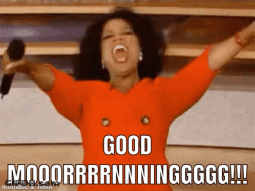 Woman In Orange Shirt Holding Microphone Says Good Moooorrrnnningggg GIF
