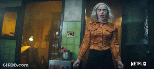 Woman In Orange Shirt In Front Of Netflix Logo GIF