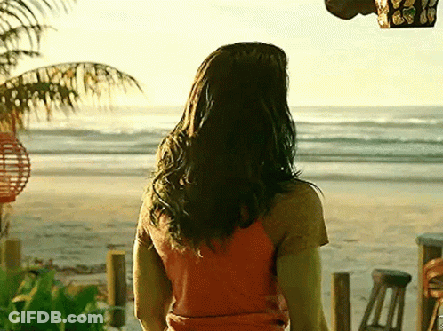 Woman In Orange Shirt Standing On Beach GIF