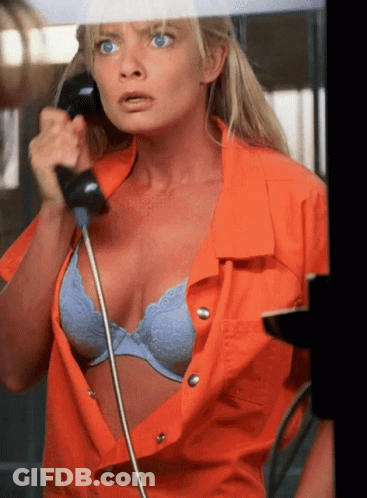 Woman In Orange Shirt Talking On Phone GIF