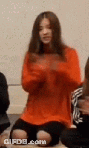 Woman In Orange Sweater Sitting GIF