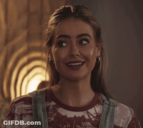 Woman In Overalls And Tie Dye Shirt Smiling GIF