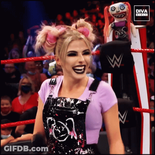 Woman In Overalls In Wrestling Ring With Diva Doll GIF