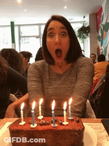 Woman In Party Hat Smiling Holding Candle GIF