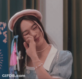 Woman In Pearl Necklace And Pink Hat Wiping Face GIF