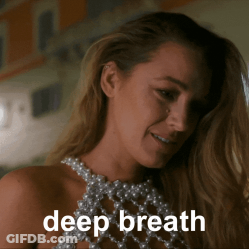 Woman In Pearl Top Saying Deep Breath GIF
