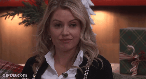Woman In Pearls And Black Sweater By Christmas Tree GIF