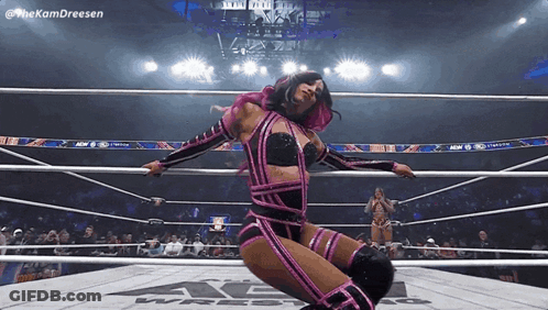 Woman In Pink And Black Wrestling Outfit Kneeling In Ring GIF