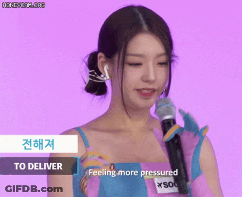 Woman In Pink And Blue Dress Holding Microphone Saying Feeling More Pressured GIF