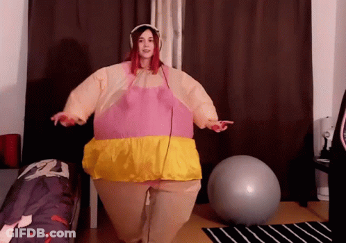 Woman In Pink And Yellow Inflatable Costume With Exercise Ball GIF