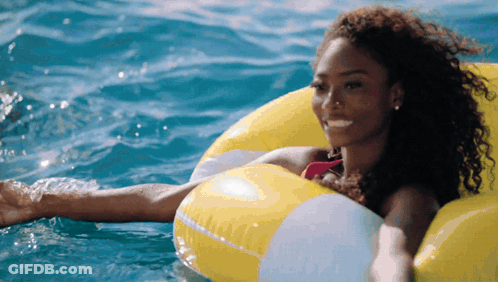 Woman In Pink Bikini Floating On Yellow Float GIF