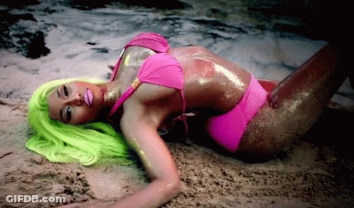 Woman In Pink Bikini With Green Hair Laying On Sand GIF