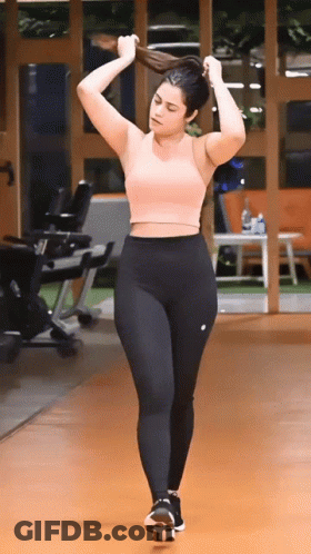 Woman In Pink Crop Top And Black Leggings In Gym GIF