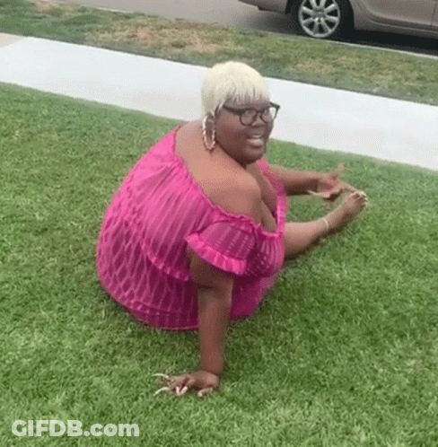 Woman In Pink Dress And Glasses Sitting On Grass GIF