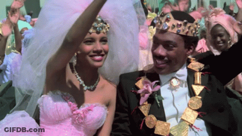 Woman In Pink Dress And Man In Black Suit Smiling GIF