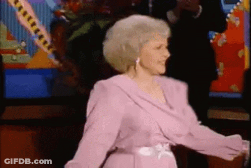 Woman In Pink Dress Dancing In Front Of Television GIF