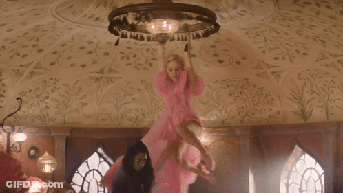 Woman In Pink Dress Flying Before Chandelier GIF