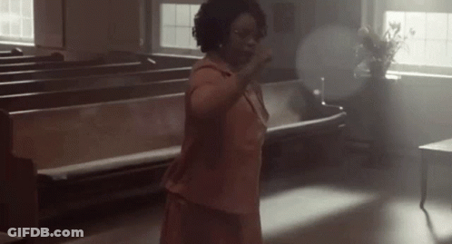 Woman In Pink Dress Hands Up In Church GIF