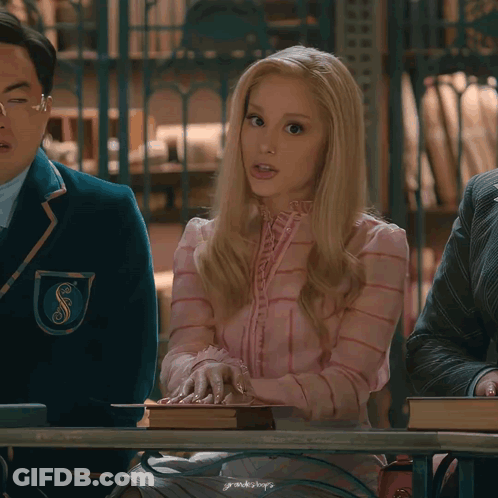 Woman In Pink Dress Holding Book At Table GIF