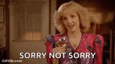 Woman In Pink Dress Holding Wine Saying Sorry Not Sorry GIF