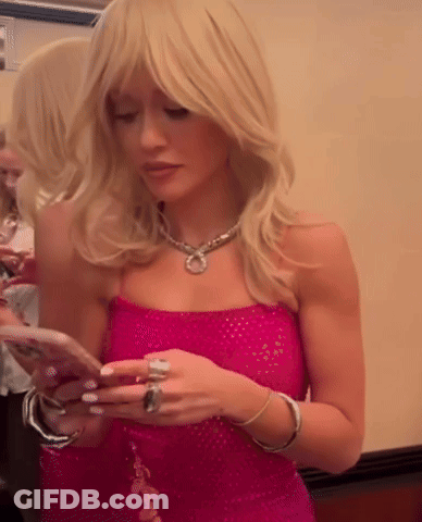 Woman In Pink Dress Looking At Cell Phone GIF