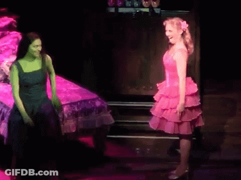 Woman In Pink Dress Next To Woman In Green GIF