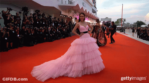 Woman In Pink Dress On Red Carpet Getty Images GIF