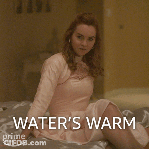 Woman In Pink Dress Sitting On Bed Water's Warm GIF