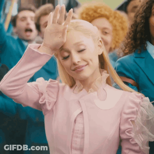 Woman In Pink Dress Smiling And Waving Hand GIF