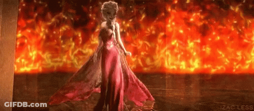 Woman In Pink Dress Standing In Front Of Fire GIF