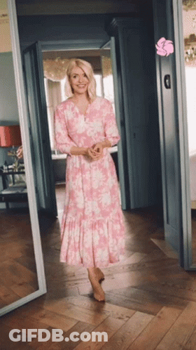 Woman In Pink Dress Standing In Hallway GIF